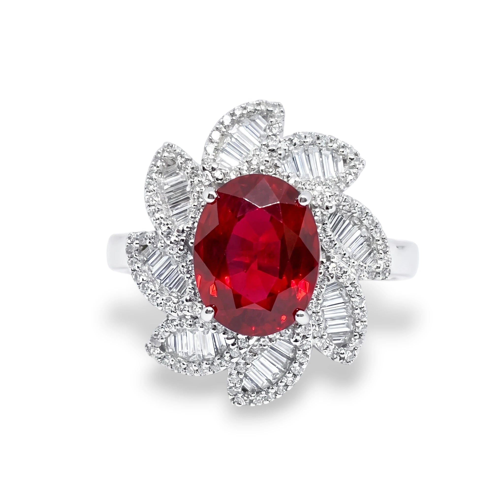 A silver-toned ring featuring a large oval-cut red gemstone surrounded by a petal-shaped cluster of baguette-cut clear stones, shown on a clean white background.